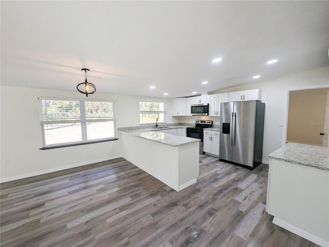 kitchen featuring white cabinetry, stainless steel appliances, light stone counters, decorative light fixtures, and kitchen peninsula