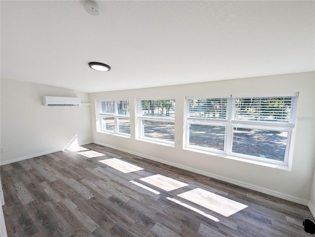 unfurnished room with dark hardwood / wood-style floors and a wall mounted AC