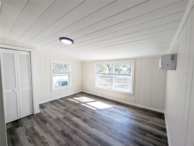 unfurnished bedroom with vaulted ceiling, wood ceiling, dark hardwood / wood-style flooring, and a closet