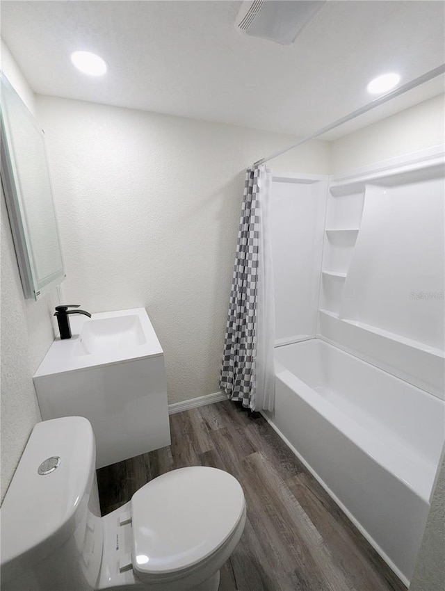 full bathroom featuring hardwood / wood-style flooring, shower / tub combo with curtain, vanity, and toilet