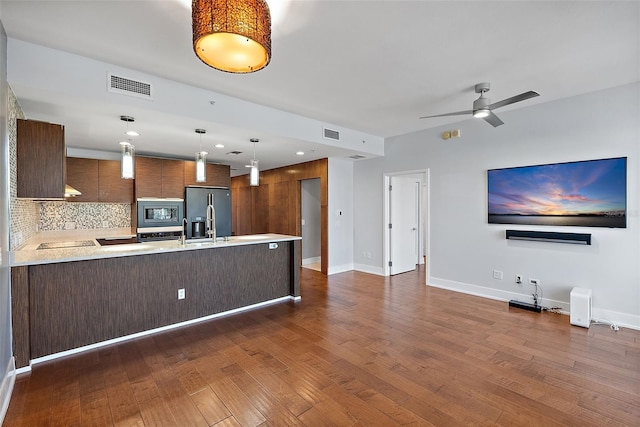 kitchen with pendant lighting, stainless steel appliances, dark hardwood / wood-style floors, and tasteful backsplash