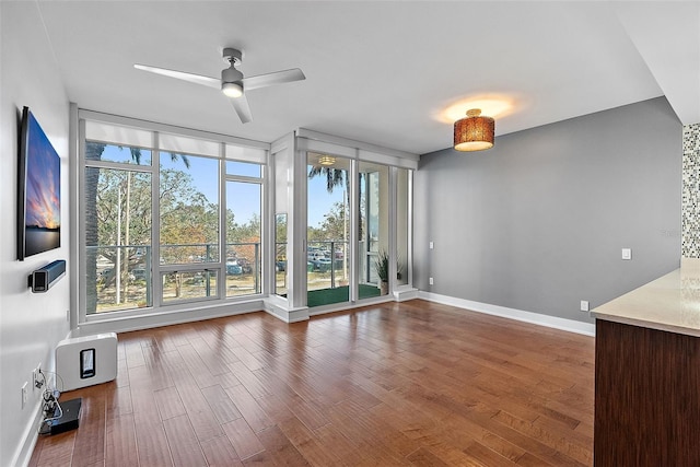 spare room featuring hardwood / wood-style flooring, floor to ceiling windows, and ceiling fan