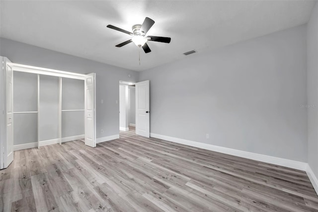 unfurnished bedroom featuring light hardwood / wood-style flooring, a closet, and ceiling fan