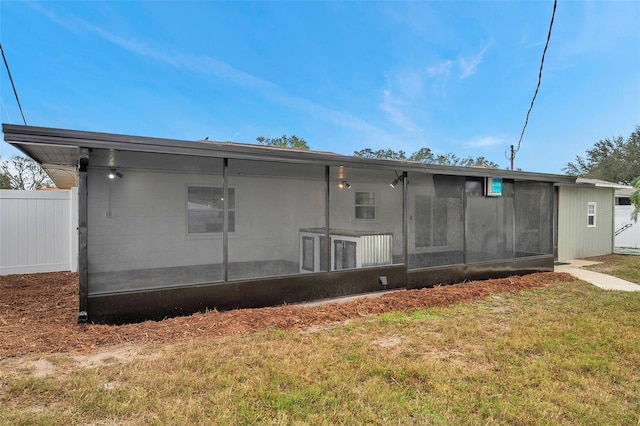 rear view of house featuring a yard