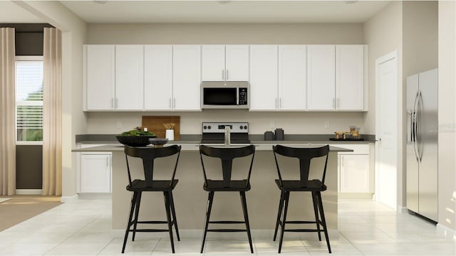 kitchen featuring stainless steel appliances, white cabinetry, a kitchen island with sink, and light tile patterned floors