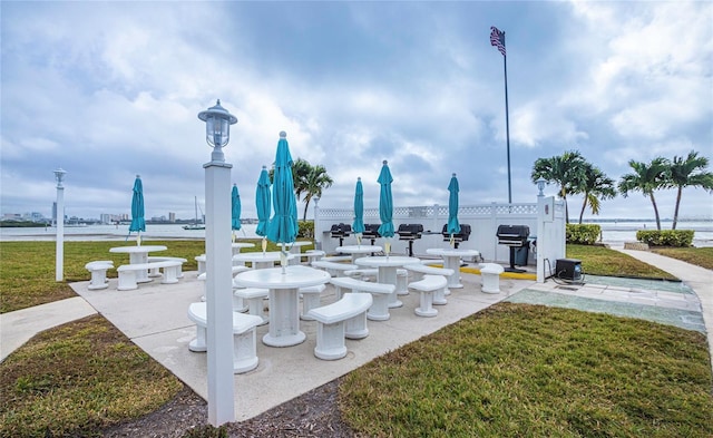 surrounding community featuring a water view and a lawn