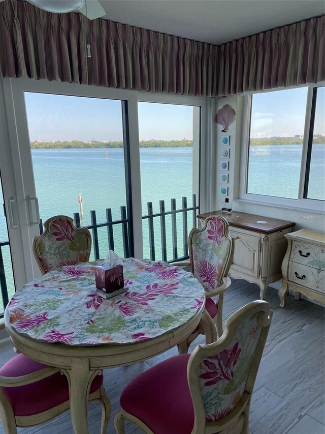 dining area featuring a water view, plenty of natural light, and light hardwood / wood-style floors