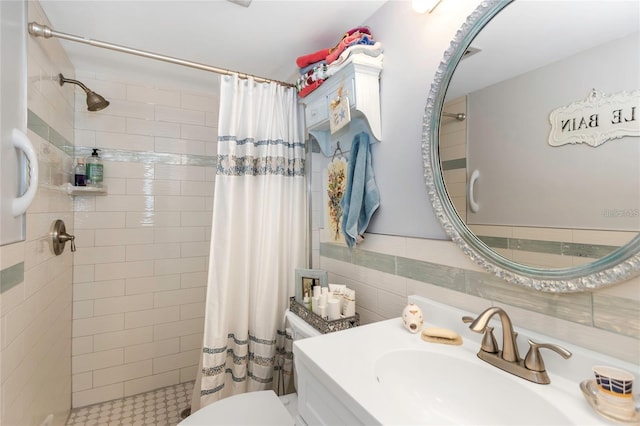 bathroom featuring a shower with curtain, vanity, toilet, and tile walls