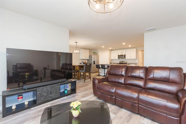 living room with a chandelier and light hardwood / wood-style flooring