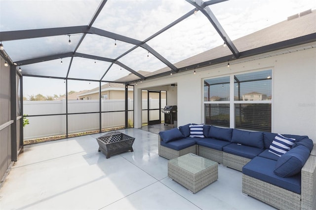 view of patio featuring a grill, glass enclosure, and an outdoor living space with a fire pit