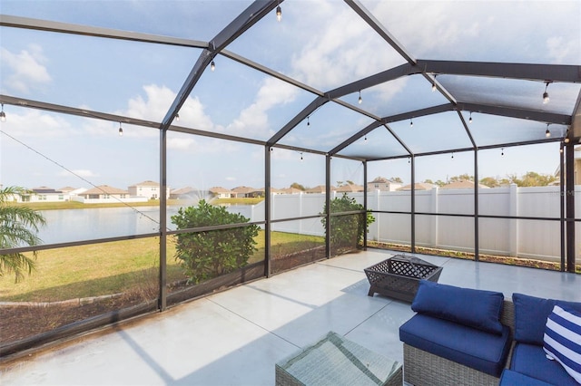 sunroom with lofted ceiling and a water view