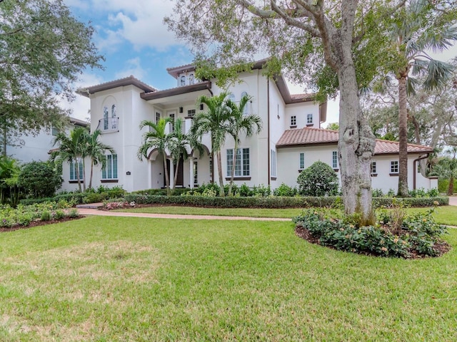 mediterranean / spanish house featuring a front lawn