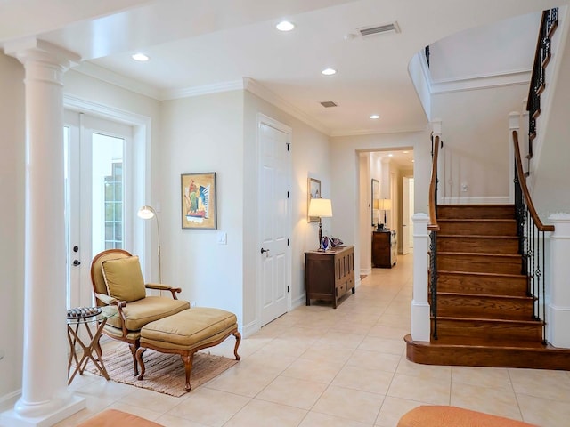 sitting room featuring light tile patterned floors, crown molding, and decorative columns