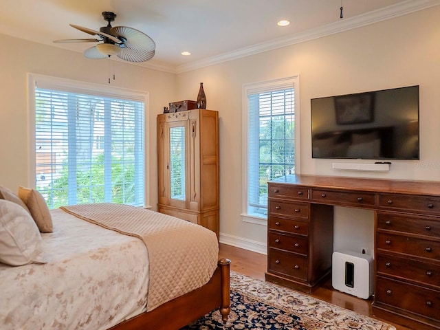 bedroom with hardwood / wood-style flooring, crown molding, and ceiling fan