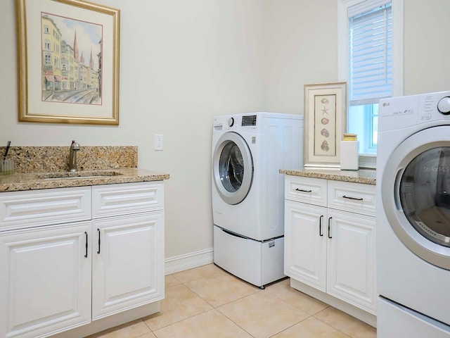 laundry area featuring sink, cabinets, and light tile patterned flooring