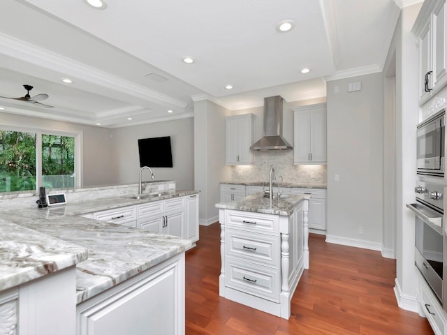 kitchen featuring white cabinetry, appliances with stainless steel finishes, sink, and wall chimney range hood