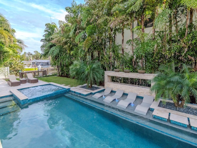 view of pool with an in ground hot tub