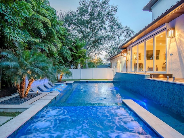 pool at dusk with pool water feature