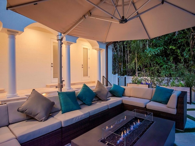 view of patio with an outdoor living space with a fire pit