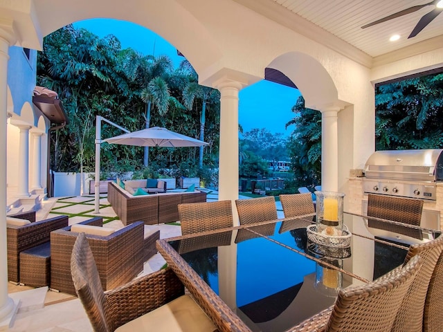 patio terrace at dusk with area for grilling, an outdoor hangout area, ceiling fan, and grilling area