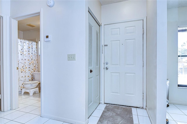 doorway with light tile patterned floors