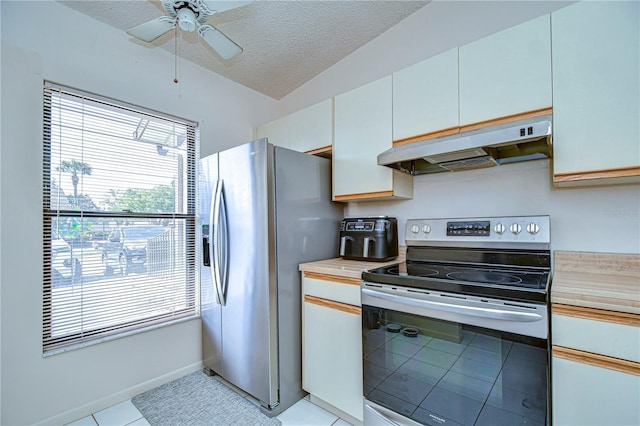 kitchen with premium range hood, white cabinetry, a textured ceiling, light tile patterned floors, and appliances with stainless steel finishes