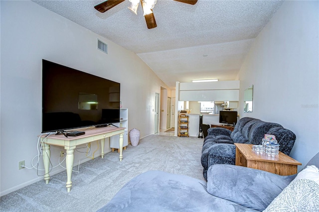 living room featuring light carpet, ceiling fan, vaulted ceiling, and a textured ceiling