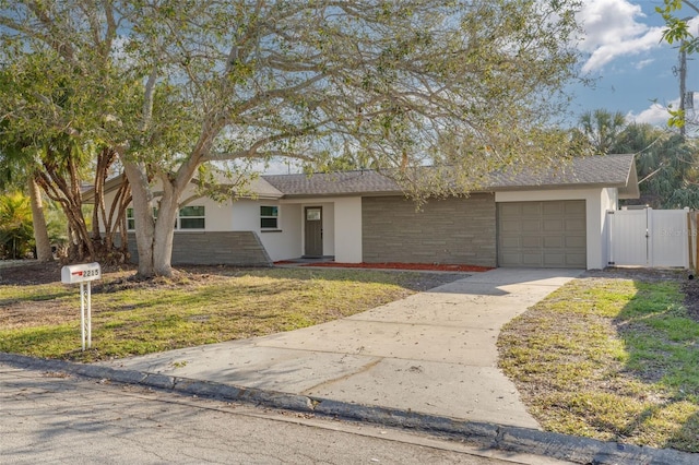 ranch-style home featuring a garage and a front lawn