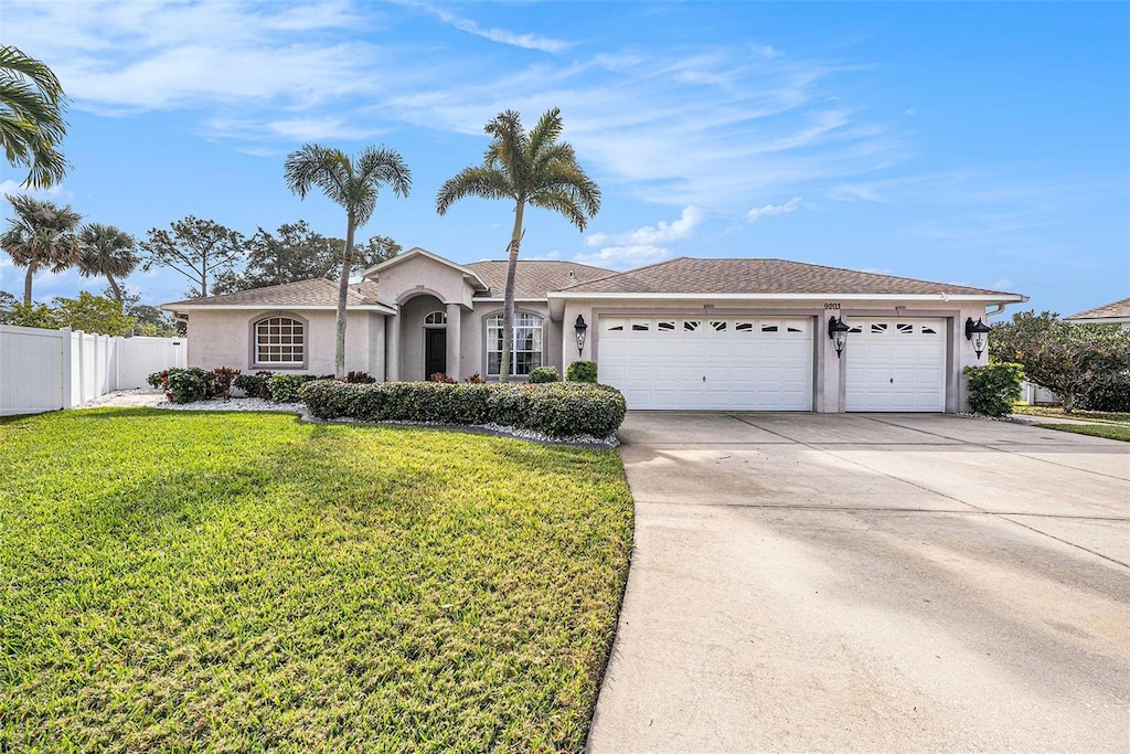 single story home featuring a garage and a front lawn