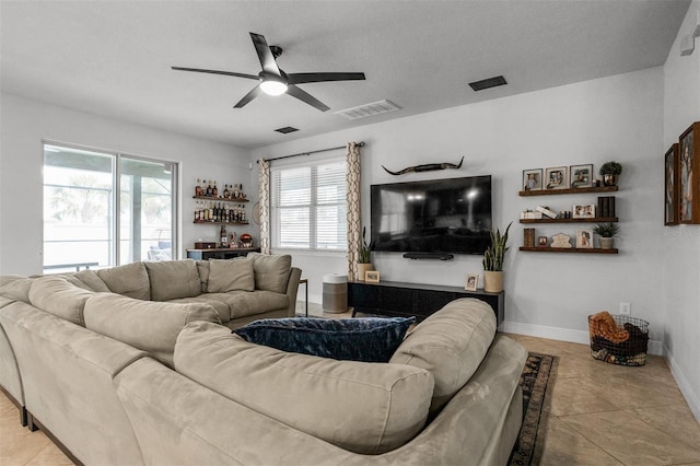 living room featuring indoor bar, light tile patterned floors, and ceiling fan