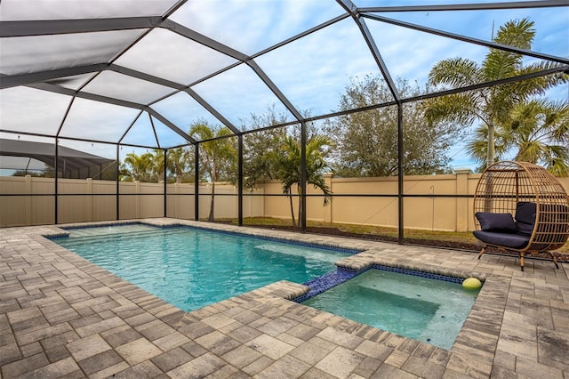 view of swimming pool featuring an in ground hot tub, a patio area, and glass enclosure