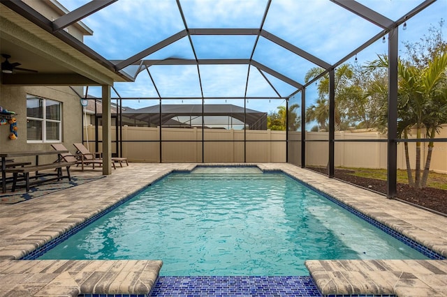 view of swimming pool featuring a patio and glass enclosure