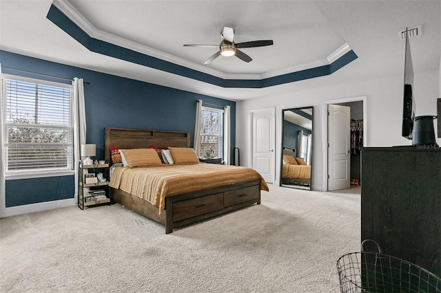 carpeted bedroom featuring multiple windows, ornamental molding, and a raised ceiling