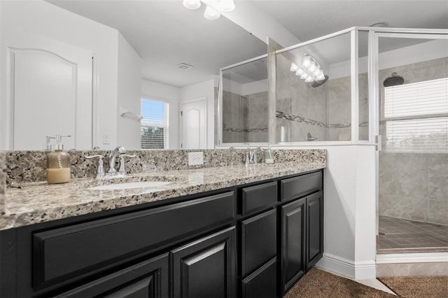 bathroom with vanity and a shower with shower door