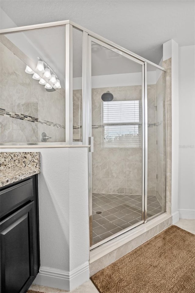 bathroom with tile patterned floors, vanity, and a shower with shower door