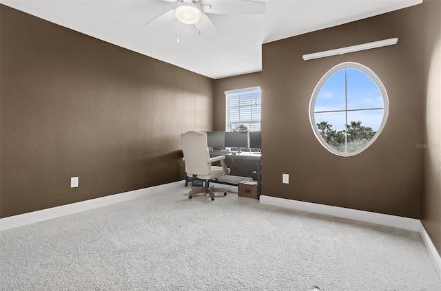 carpeted office space featuring ceiling fan