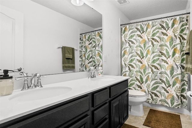 bathroom featuring tile patterned floors, vanity, and toilet