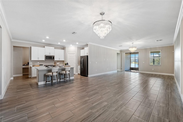 unfurnished living room with ornamental molding and a chandelier