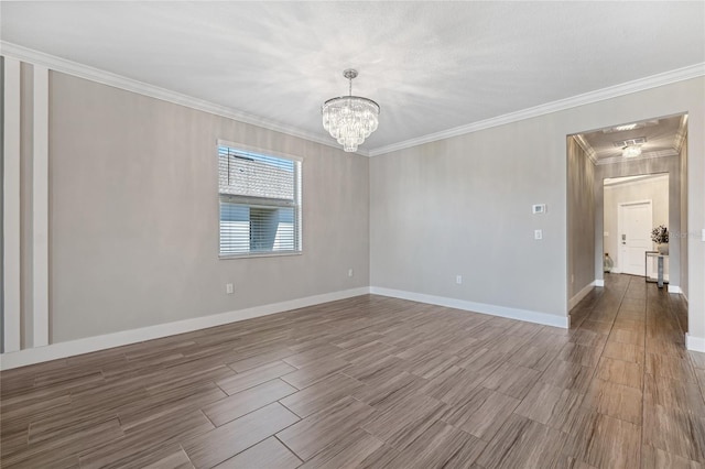 empty room with hardwood / wood-style flooring, crown molding, and a notable chandelier