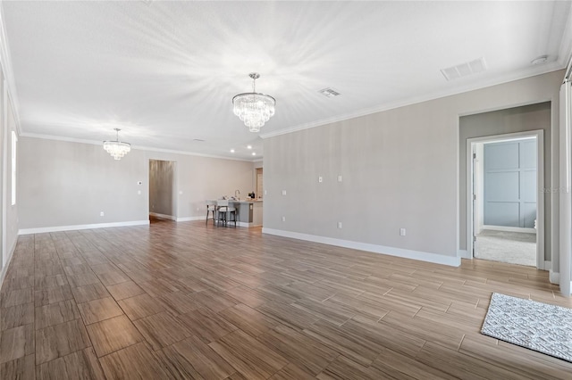 unfurnished living room featuring ornamental molding and a chandelier