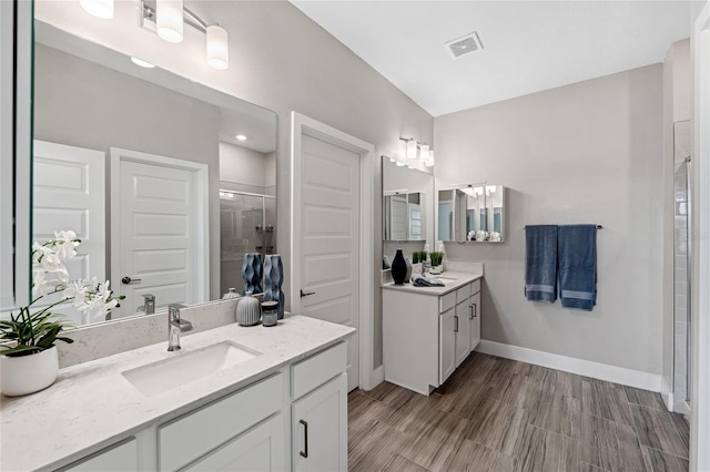 bathroom with vanity and a shower with shower door