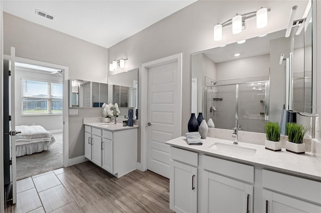 bathroom featuring walk in shower, vanity, and hardwood / wood-style flooring