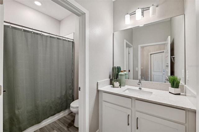 bathroom with hardwood / wood-style flooring, vanity, and toilet