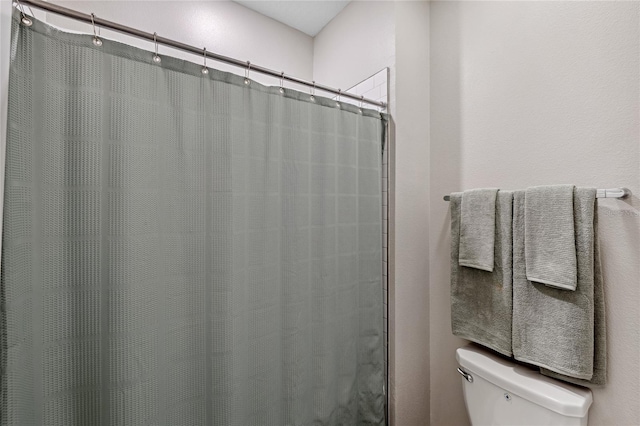 bathroom featuring toilet and a shower with shower curtain