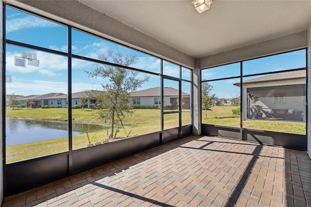 unfurnished sunroom featuring a water view