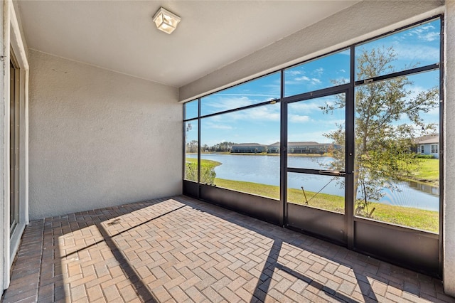 unfurnished sunroom featuring a water view