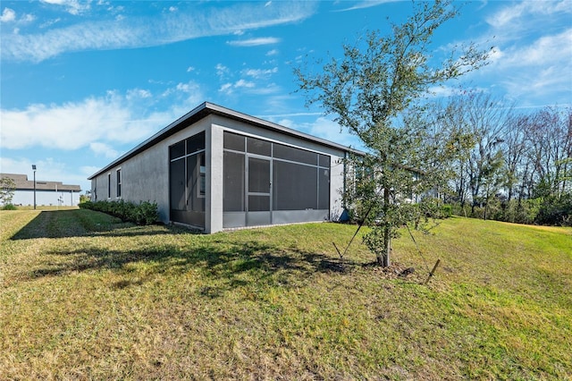 exterior space featuring a sunroom and a lawn