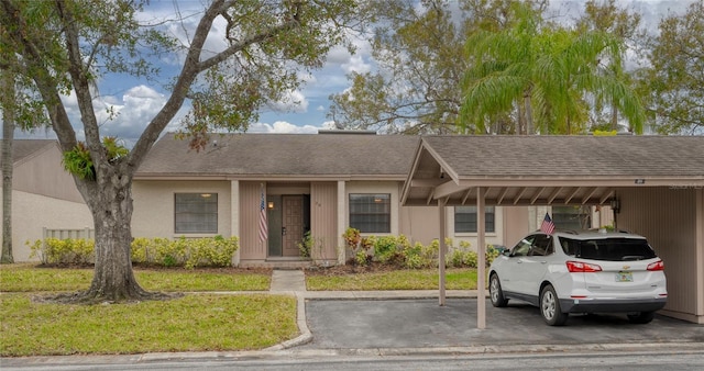 view of front of home with a carport and a front lawn