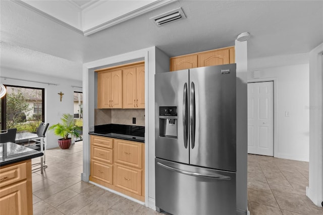 kitchen featuring tasteful backsplash, light tile patterned flooring, light brown cabinets, and stainless steel refrigerator with ice dispenser