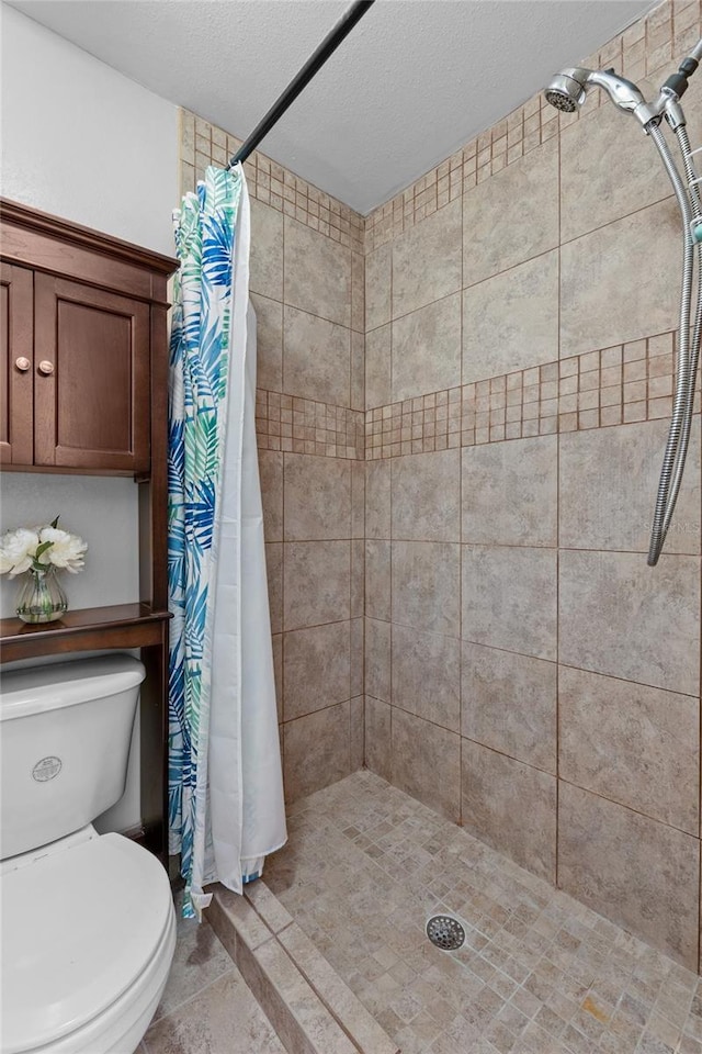 bathroom featuring curtained shower, toilet, and a textured ceiling